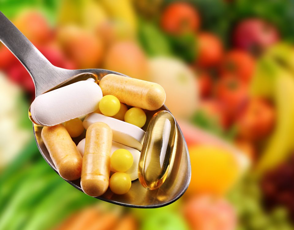 spoon with dietary supplements on fruits background